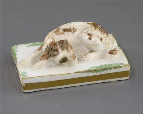 A Rockingham porcelain figure of a recumbent cocker spaniel, c.1830, L. 6.8cm